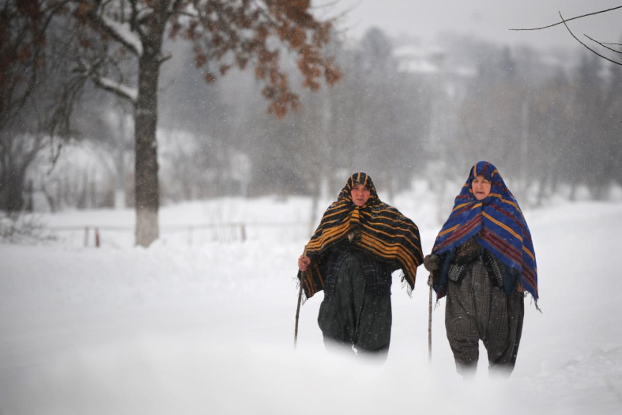 'Bulgarian Muslim women walk during a snowfall in the village of Rakovski, some 355 km north-east from capital Sofia on January 28, 2012. Four people died in Romania and one in Bulgaria as snowstorms 