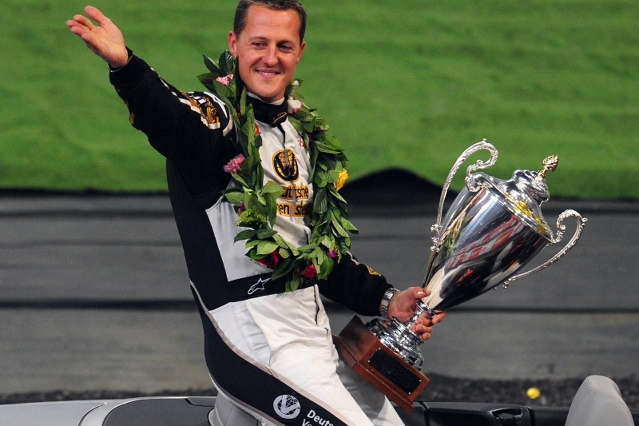 'Seven-time Formula One world champion Michael Schumacher of Germany acknowledges the crowd with his runner-up trophy after losing to Mattias Ekstrom of Sweden in the final of the Race of Champions in