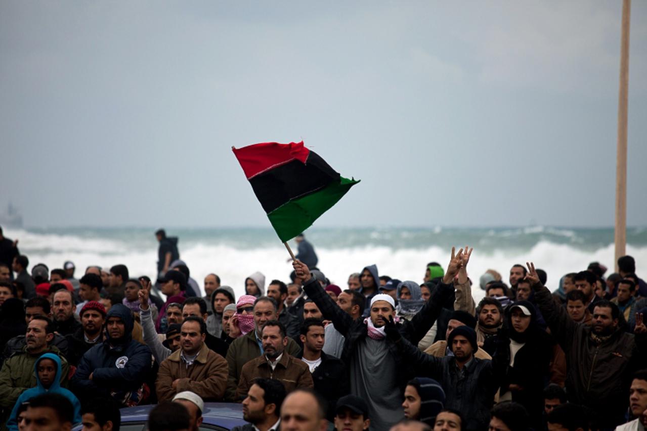 'A protester waves a Libyan old flag during a demonstration on February 25, 2011 in Benghazi. Euphoria in Libya\'s second city Benghazi gave way to growing concern that it remains vulnerable to a coun