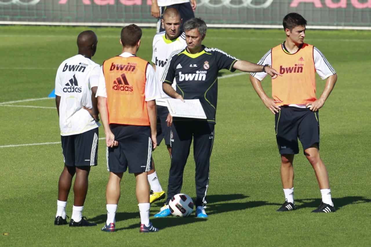 'Real Madrid\'s new coach Jose Mourinho (C) gives instructions to players next to Karim Benzema (3rd L) during Real Madrid\'s first training session in Madrid July 16, 2010.   REUTERS/Andrea Comas (SP
