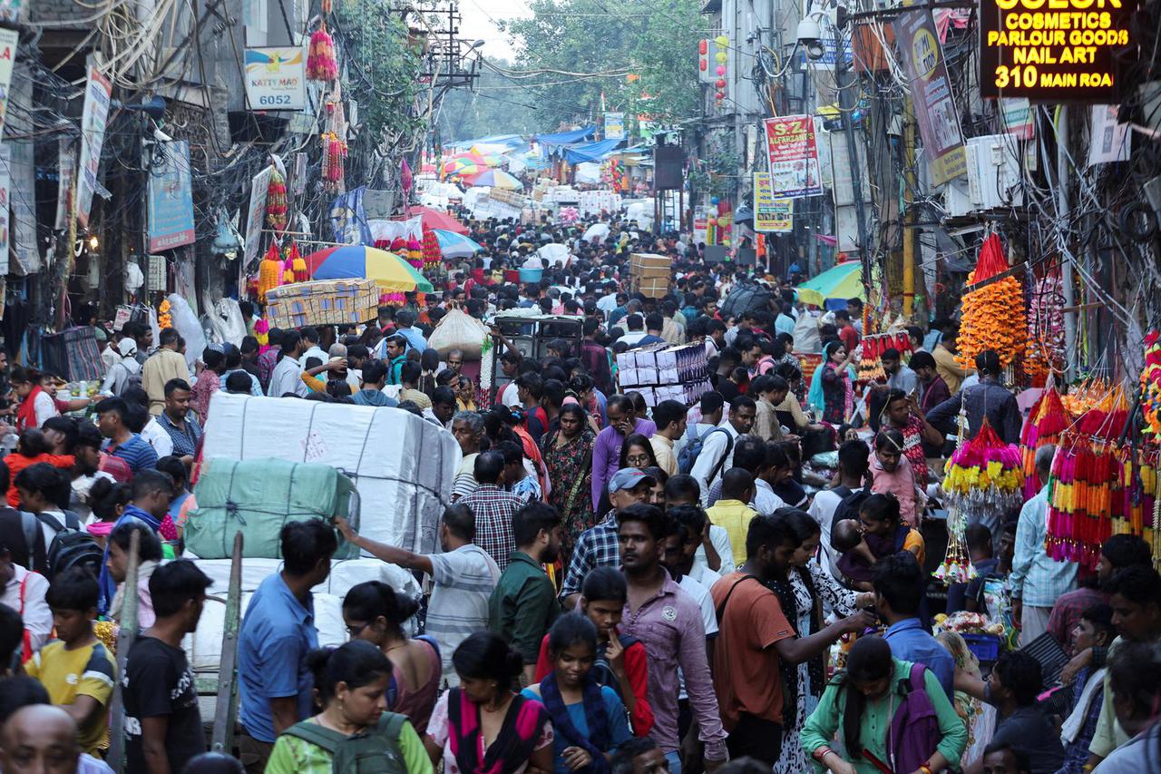 FILE PHOTO: People shop at a crowded market ahead of Diwali, the Hindu festival of lights, in the old quarters of Delhi