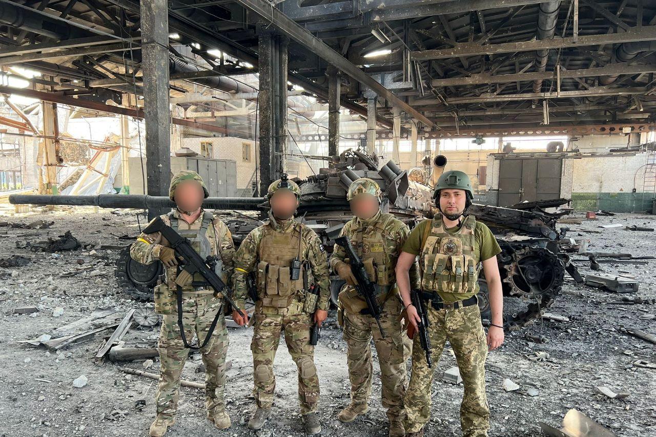 Ukraine's Military Intelligence chief Budanov poses for a picture with his brothers-in-arms in front of a destroyed tank in an undisclosed location in Ukraine