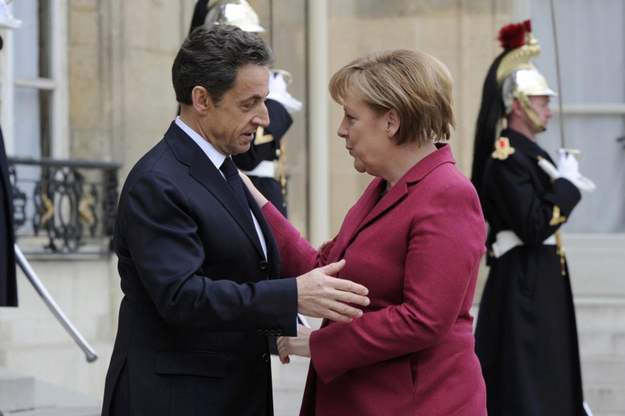 \'France\'s President Nicolas Sarkozy (L) greets German Chancellor Angela Merkel at the Elysee Palace ahead of international talks on Libya in Paris March 19, 2011. World leaders gather in Paris on Sa