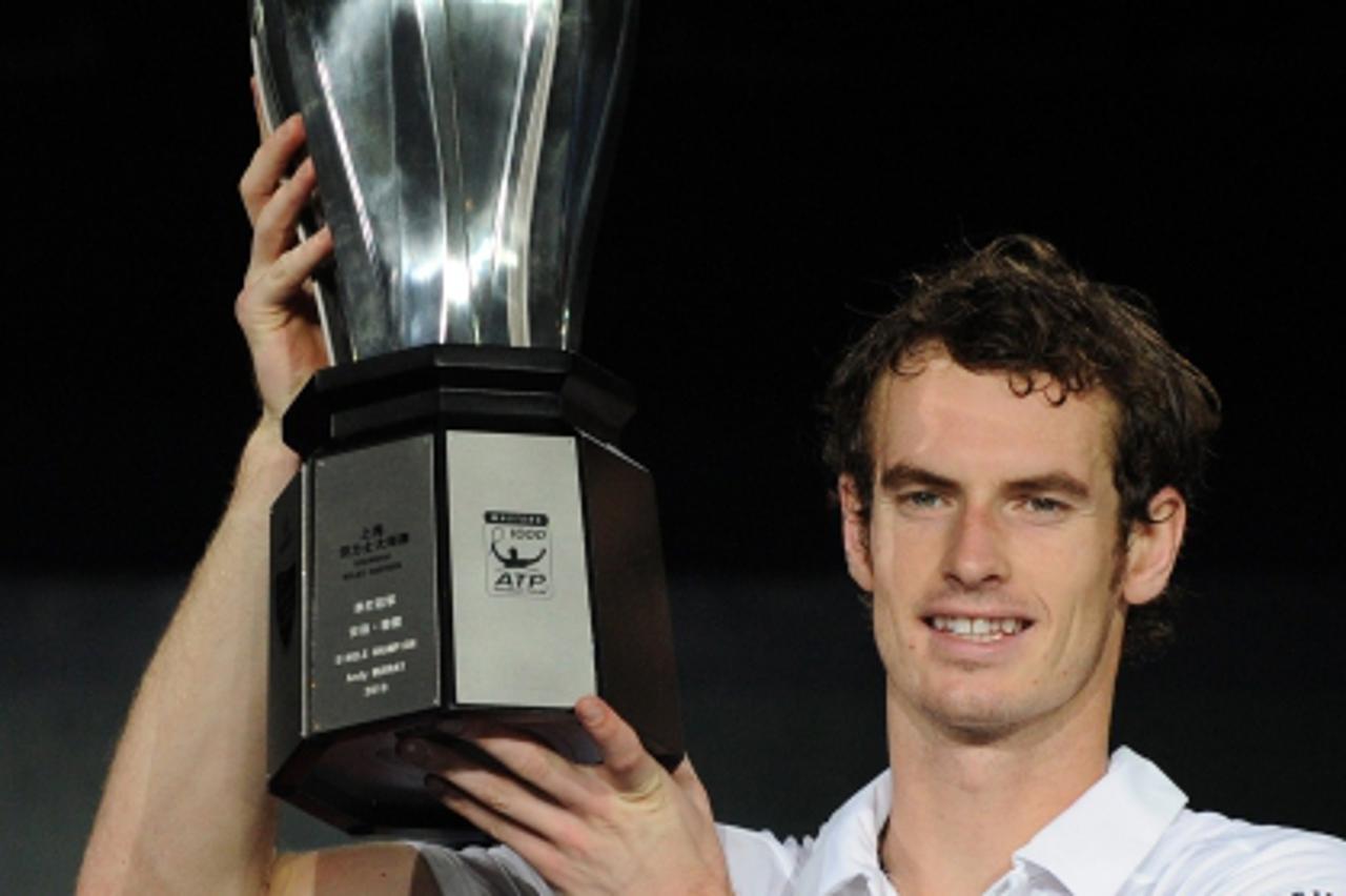 'Andy Murray of Britain holds the championship trophy after defeating Roger Federer of Switzerland in the final at the Shanghai Masters ATP tennis tournament on October 17, 2010 in Shanghai. Murray de
