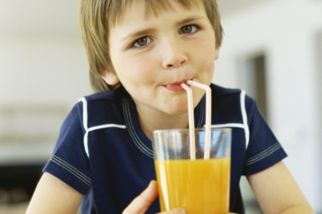 'Portrait of a boy drinking juice with straws'