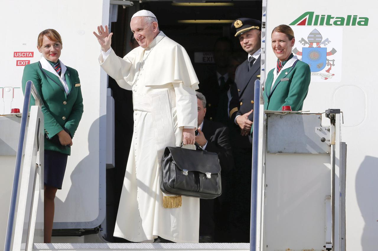 Pope Francis waves as he boards a plane at Fiumicino Airport in Rome September 19, 2015. Pope Francis begins a nine-day tour of Cuba and the United States on Saturday where he will see both the benefits and complexities of a fast-evolving detente between 