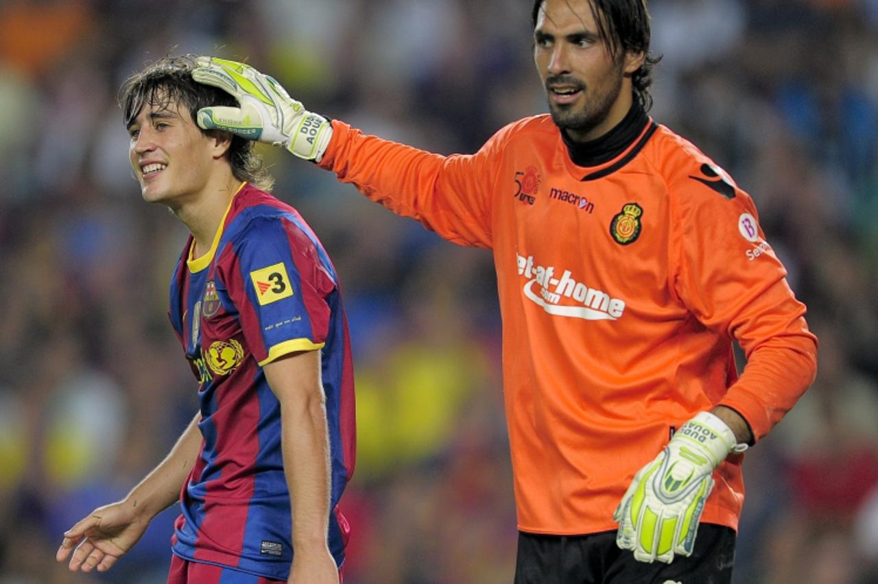 'Mallorca\'s Argentinian goalkeeper Israeli goalkeeper Dudu Aouate (R) touches the head  of Barcelona\'s forward Bojan Krkic during their first league football match between Barcelona and Mallorca at 