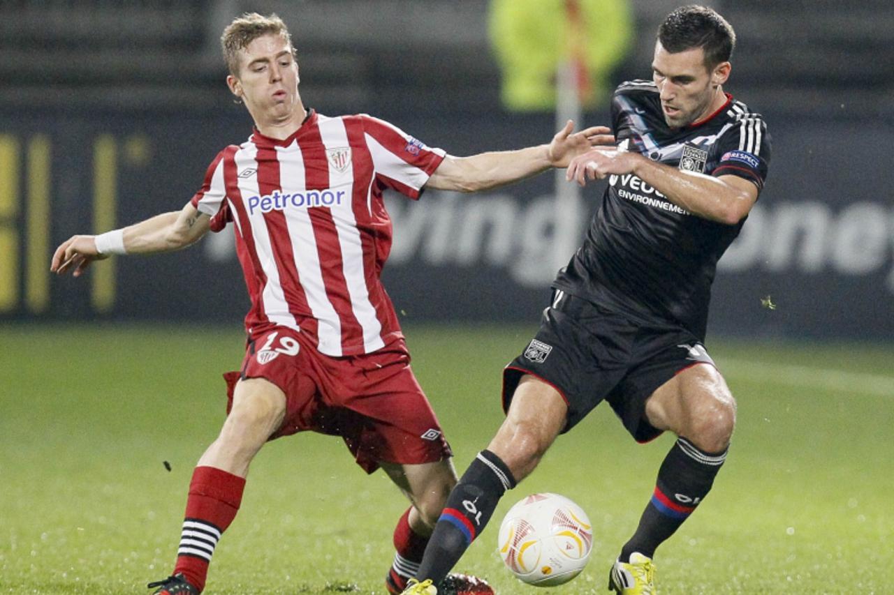 'Olympique Lyon\'s  Anthony Reveillere (R) challenges Iker Muniain of Athletic Bilbao during their Europa League soccer match at the Gerland stadium in Lyon October 25, 2012.  REUTERS/Robert Pratta (F