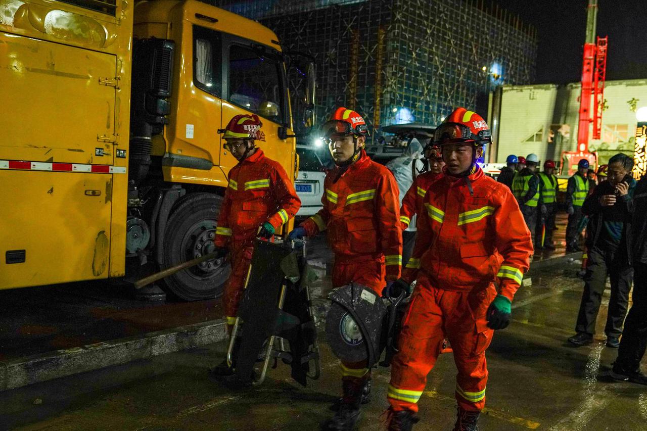 Firefighters at the site where the roof of a school gymnasium collapsed, in Qiqihar