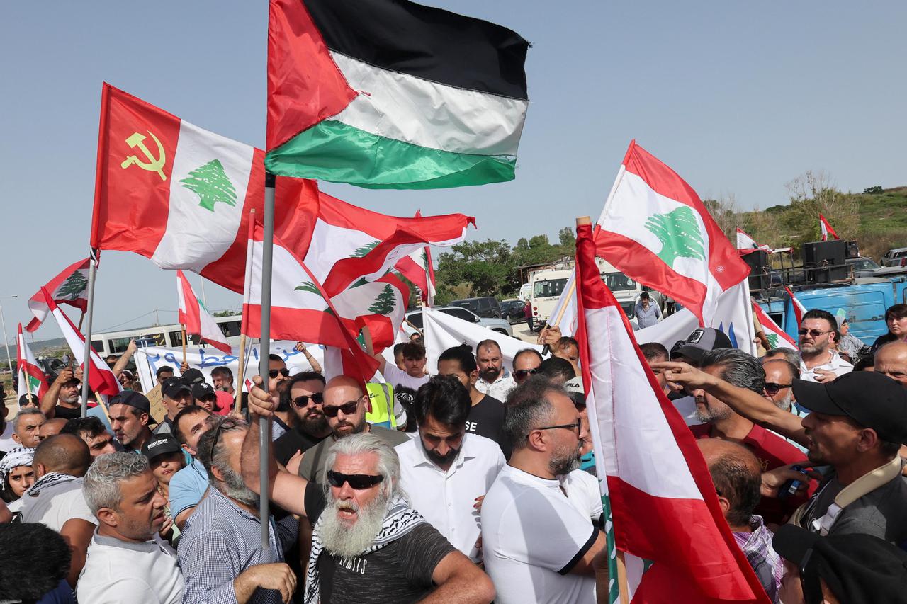 Demonstrators carry flags during a protest in Naqoura