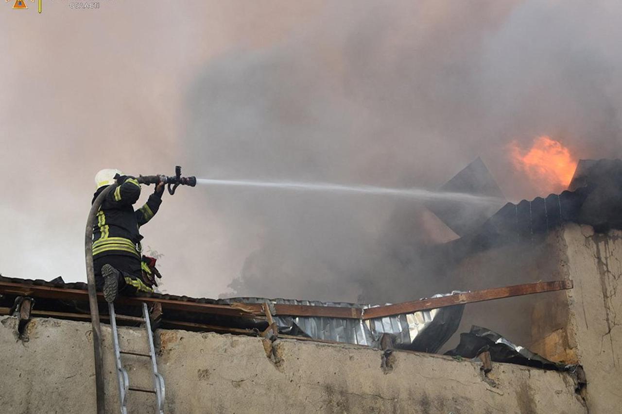 A firefighter works to douse a fire in a building, as Russia's attack on Ukraine continues, in Mykolaiv