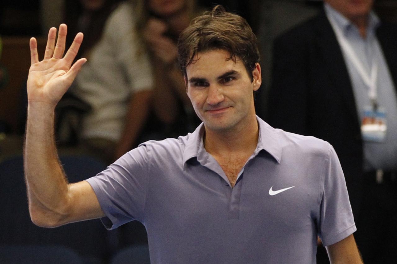 'Switzerland\'s Roger Federer waves to the crowd after defeating compatriot Stanislas Wawrinka in their quarter-final match at the Stockholm Open tennis tournament in Stockholm October 22, 2010.    RE