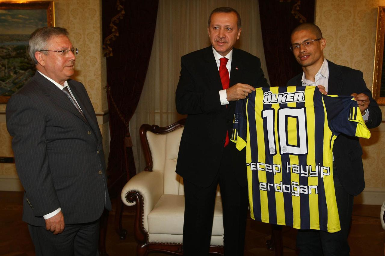 Fenerbahce Chairman Aziz Yildirim (L) and the team's Brazilian captain Alex de Souza (R) pose with Turkey's Prime Minister Tayyip Erdogan during their visit in Ankara in this April 19, 2011 file photo. A Turkish court jailed 15 more people, including top 