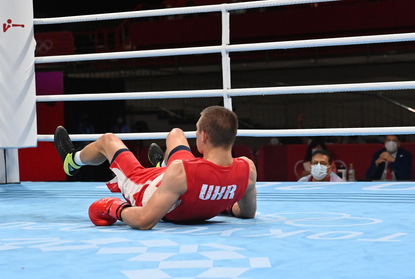 Boxing - Men's Middleweight - Final Tokyo 2020 Olympics - Boxing - Men's Middleweight - Final - Kokugikan Arena - Tokyo, Japan - August 7, 2021. Oleksandr Khyzhniak of Ukraine lies on the ground after being knocked down during his fight against Hebert Sousa of Brazil Pool via REUTERS/Luis Robayo LUIS ROBAYO