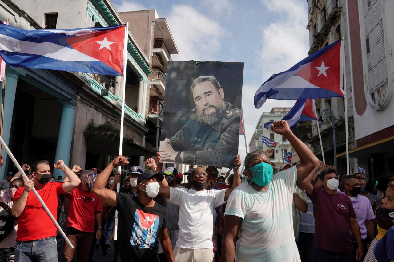 Government supporters hold a photograph of Cuba's late President Fidel Castro during protests against and in support of the government, in Havana