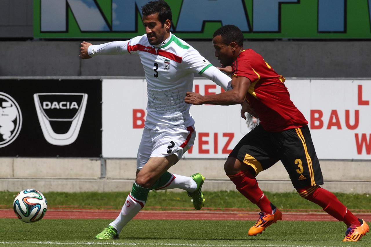 Iran's Ehsan Hajsafi (L) challenges Angola's Lunguinha during a friendly soccer match in Hartberg May 30, 2014.  REUTERS/Heinz-Peter Bader (AUSTRIA - Tags: SPORT SOCCER WORLD CUP)