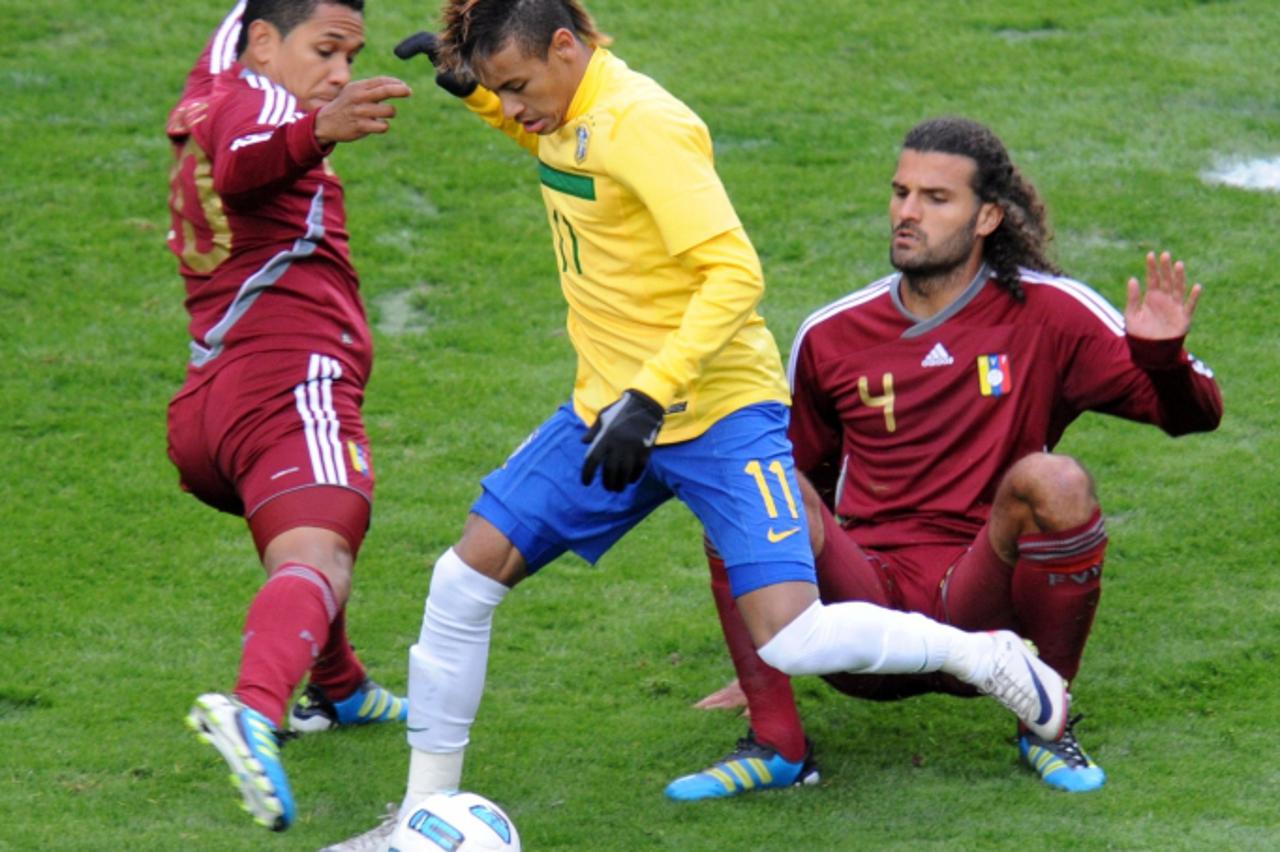 \'Brazilian forward Neymar (C) is marked by Venezuelan defenders Grenddy Perozo (L) and Oswaldo Vizcarrondo during a 2011 Copa America Group B first round football match held at the Ciudad de La Plata