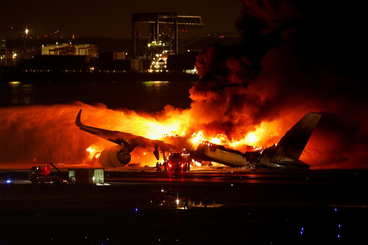 An aerial view shows burnt Japan Airlines' (JAL) Airbus A350 plane after a collision with a Japan Coast Guard aircraft at Haneda International Airport in Tokyo
