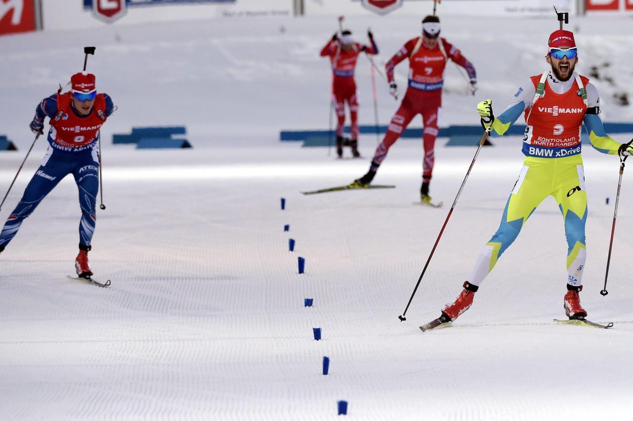 Slovenia's Jakov Fak (R) skis to finish first followed by second-placed Czech Republic's Ondrej Moravec (L) and third-placed Norway's Tarjei Boe (2nd R) during the men's 15 km Mass Start event at the IBU Biathlon World Championships in Kontiolahti March 1