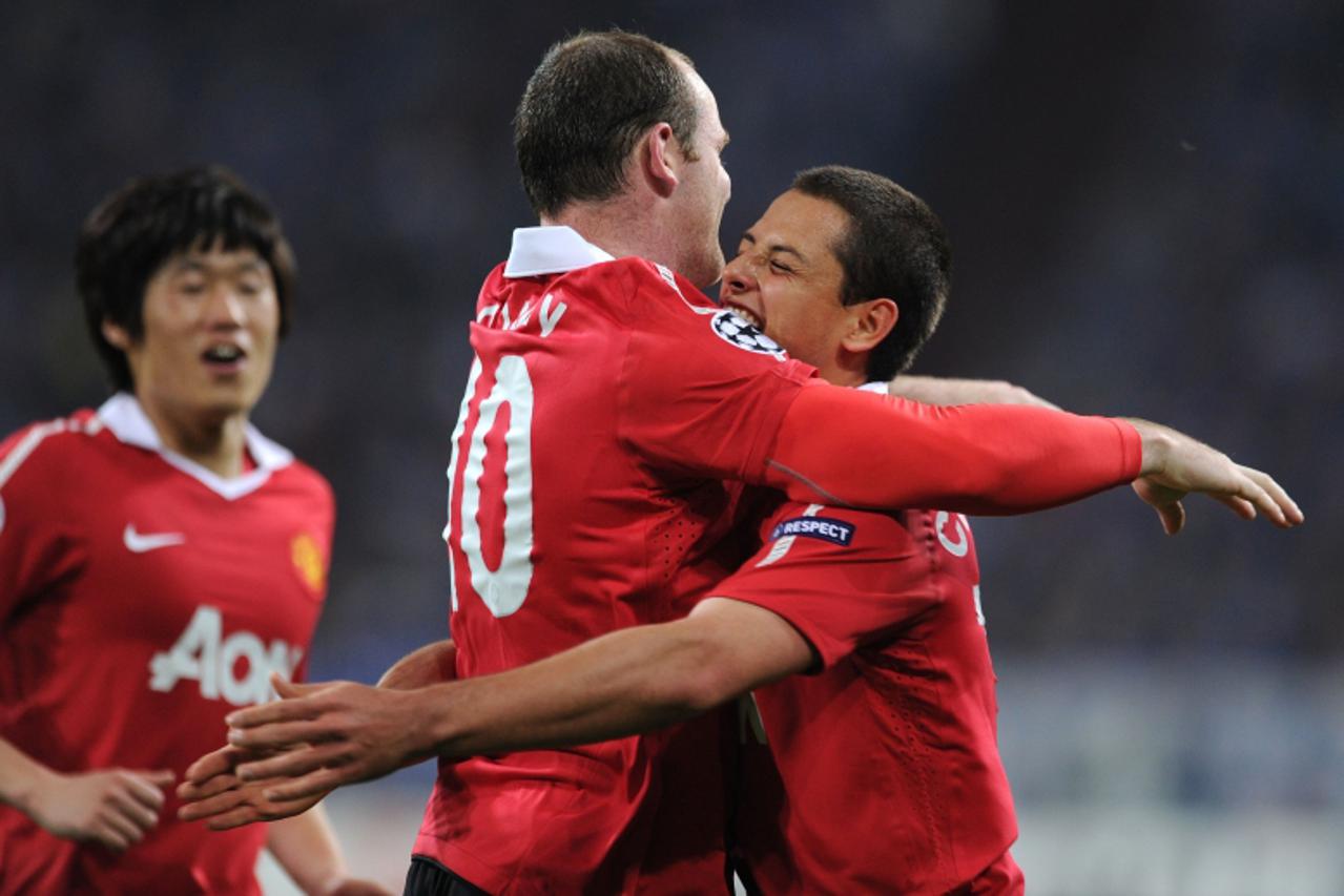 'Manchester\'s English forward Wayne Rooney (C) celebrates with his teammate Mexican forward Javier Hernandez (R) after scoring during the Champions League semi-final, first-leg match of Schalke 04 ag