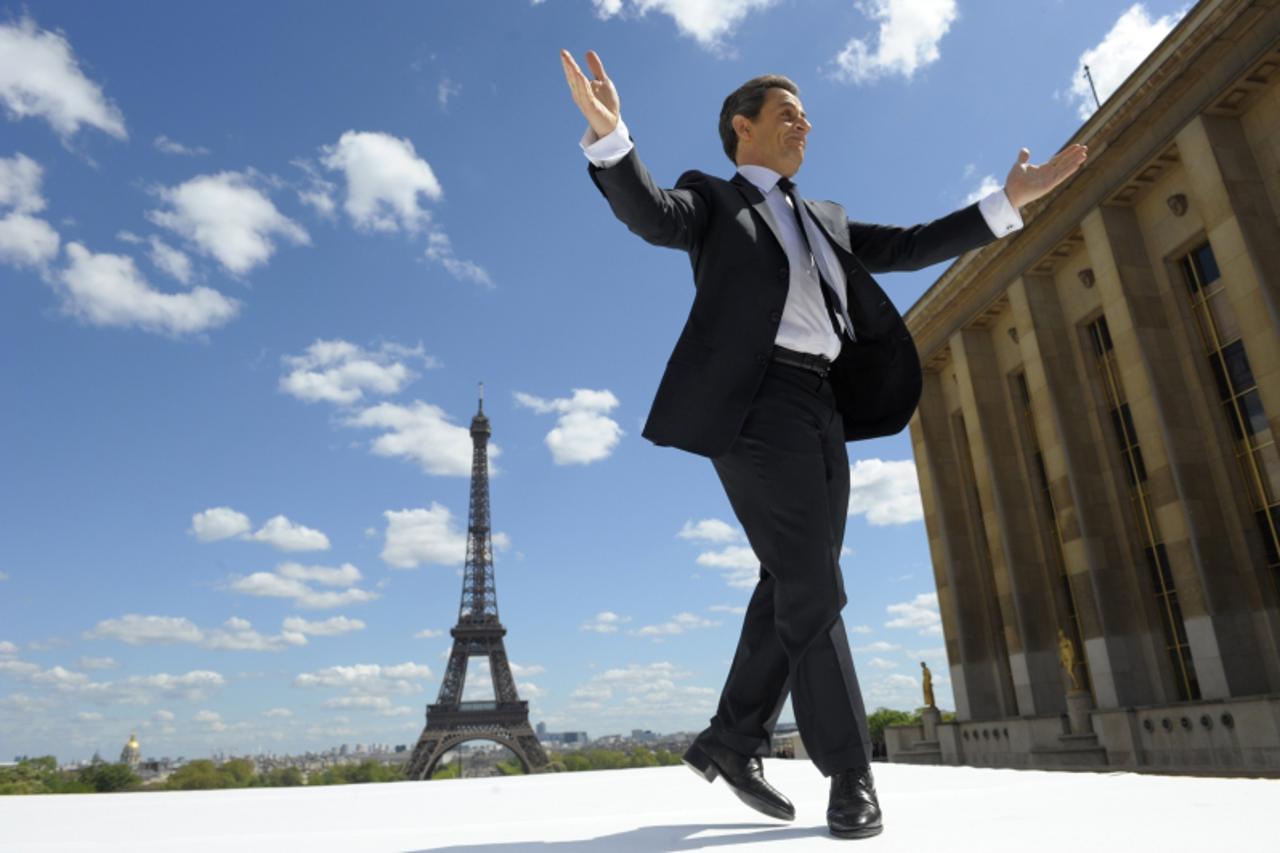 \'France\'s President and UMP party candidate for his re-election in the 2012 French presidential elections, Nicolas Sarkozy waves to supporters as he arrives on stage at Trocadero square to deliver a