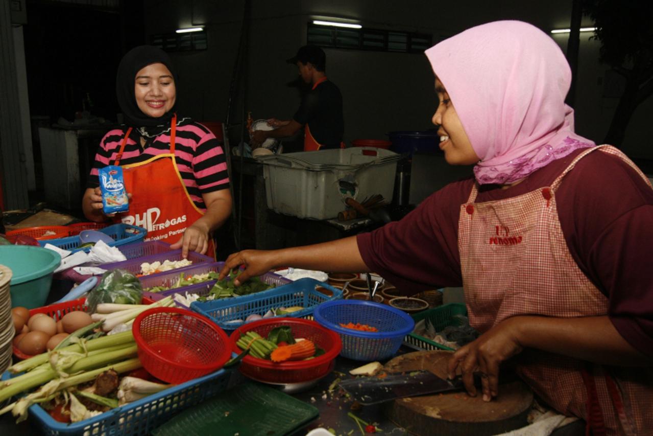 \'Najpoznatiji hrvatski zacyu0308in odlicyu0308no su prihvatile Rosidah Kalong (lijevo) i Sakinah Benee, kuharice u ribljem restoranu u malezijskom gradu Batu Feringgi. Photo: Marijan Susyu0308en