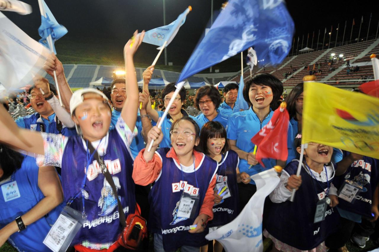 \'South Koreans cheer during a night rally to support Pyeongchang\'s bid for the 2018 Winter Olympics in Pyeongchang, 180 kms east of  Seoul, on July 6, 2011. A South Korean alpine resort making its t