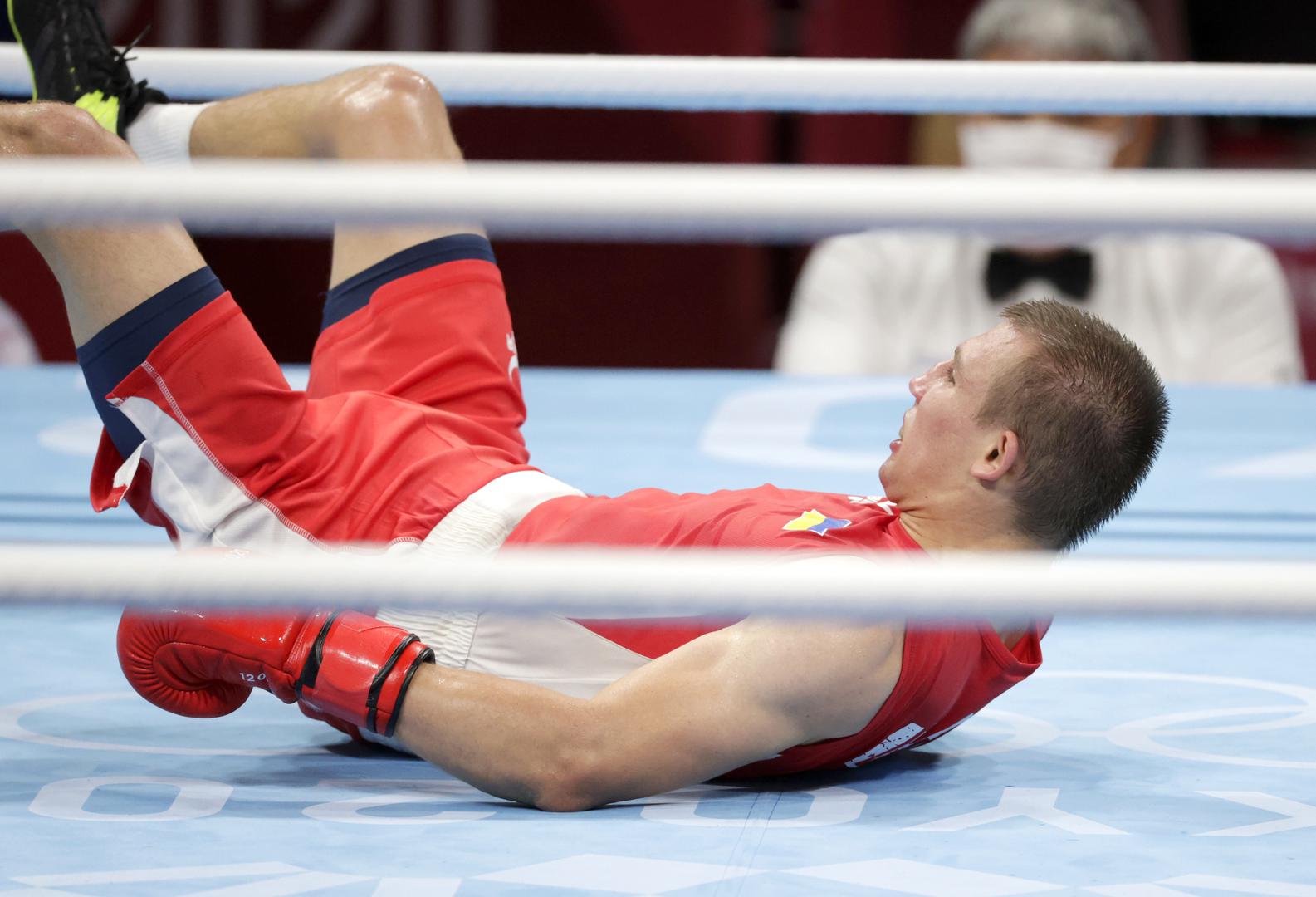 Boxing - Men's Middleweight - Final Tokyo 2020 Olympics - Boxing - Men's Middleweight - Final - Kokugikan Arena - Tokyo, Japan - August 7, 2021. Oleksandr Khyzhniak of Ukraine lies on the ground after being knocked down during his fight against Hebert Sousa of Brazil REUTERS/Ueslei Marcelino UESLEI MARCELINO