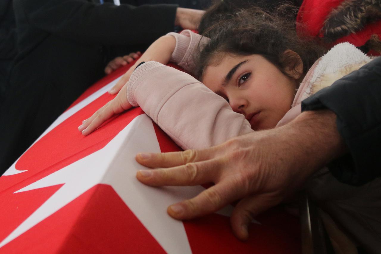 Nisa, 8-year old daughter of police officer Fethi Sekin, who was killed in the Izmir courthouse attack on Thursday, mourns over her father's coffin during a funeral ceremony in Izmir, Turkey, January 6, 2017. REUTERS/Hakan Akgun EDITORIAL USE ONLY. NO RES