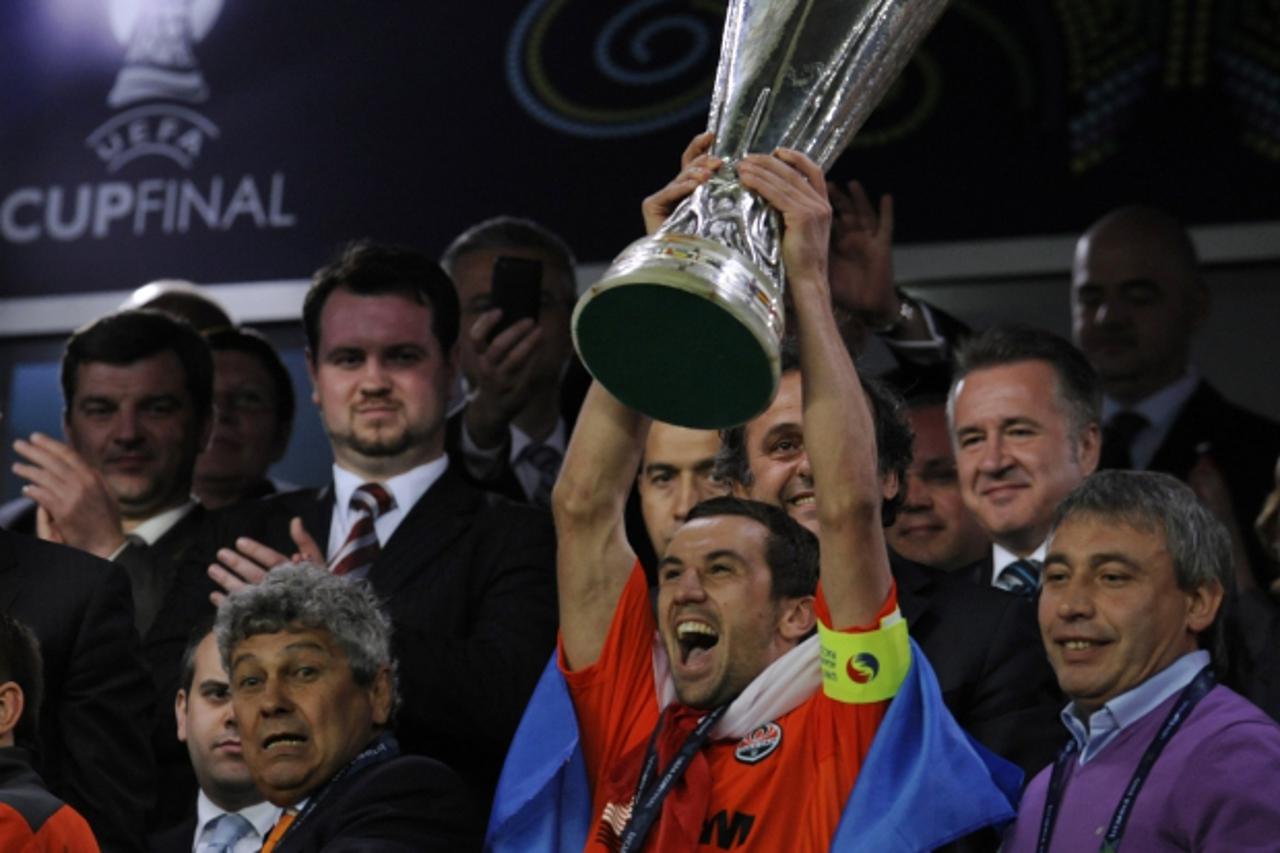 'Shakhtar Donetsk\'s Croatian midfielder and captain Darijo Srna (3rd R) celebrates with the UEFA Cup trophy next to Shakhtar Donetsk\'s Romanian head coach Mircea Lucescu (L) after their UEFA Cup fin