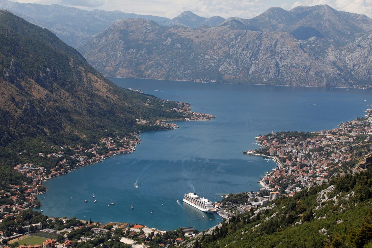 Norwegian mega cruise ship docked in front of the Old Town of Kotor