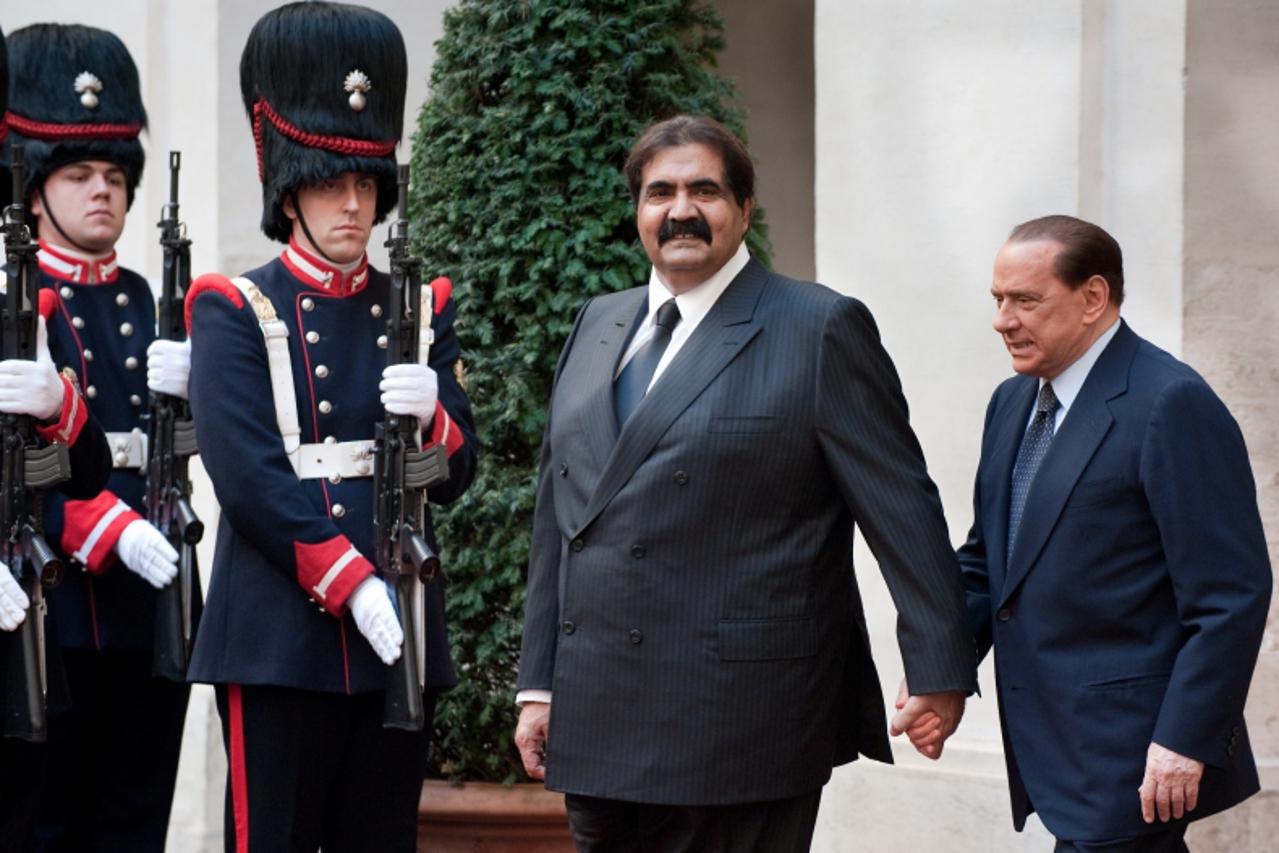 'Italian Prime Minister Silvio Berlusconi welcomes Sheikh Hamid bin Khalifa Al-Thani, Emir of Qatar (C) upon his arrival at Chigi Palace in Rome on November 17, 2009. The Emir is in Italy for the Worl