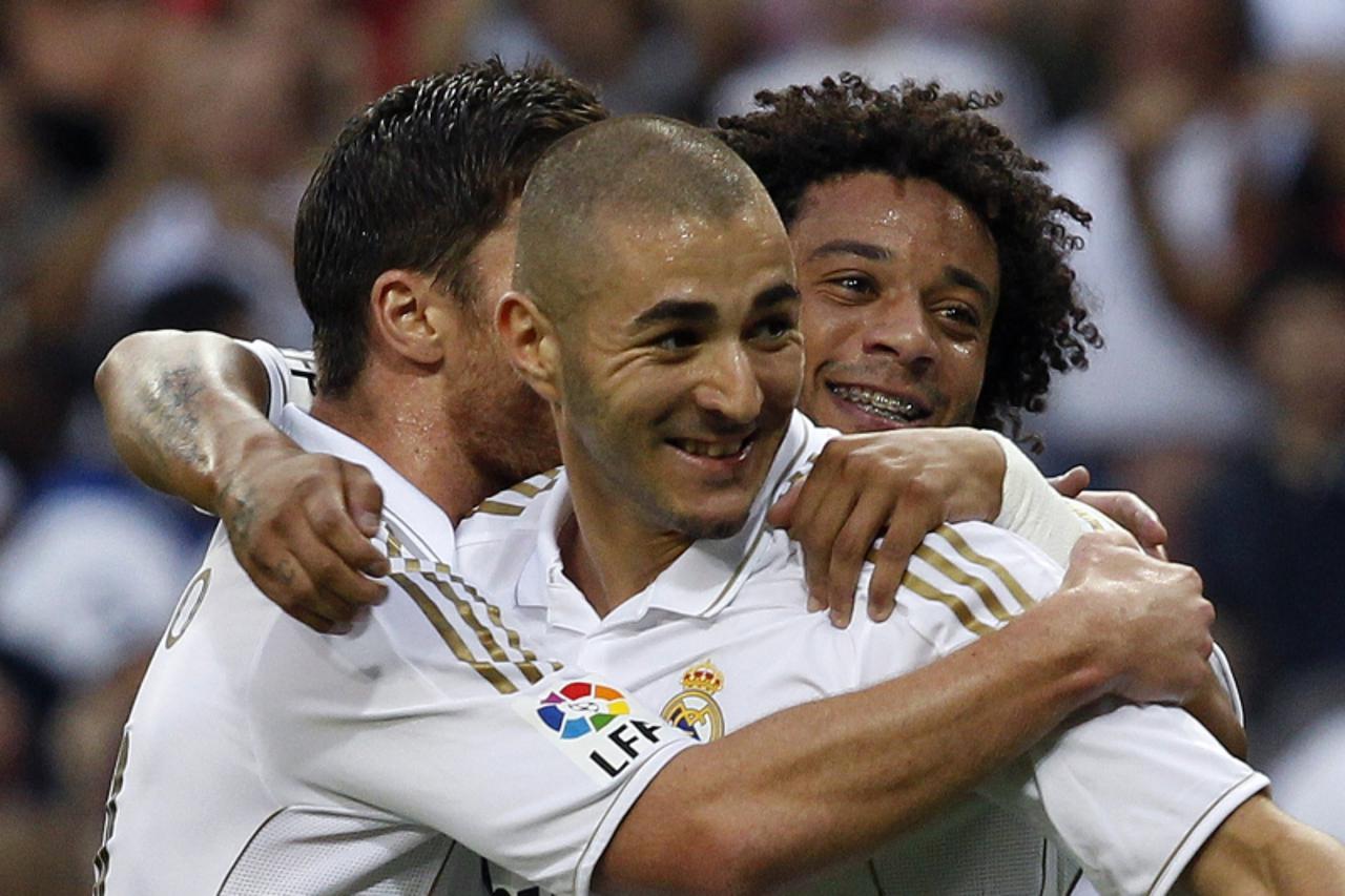 'Real Madrid\'s Karim Benzema (C) celebrates his goal against Getafe with teammate Marcelo and Xabi Alonso (L) during their Spanish first division soccer match at Santiago Bernabeu stadium in Madrid S