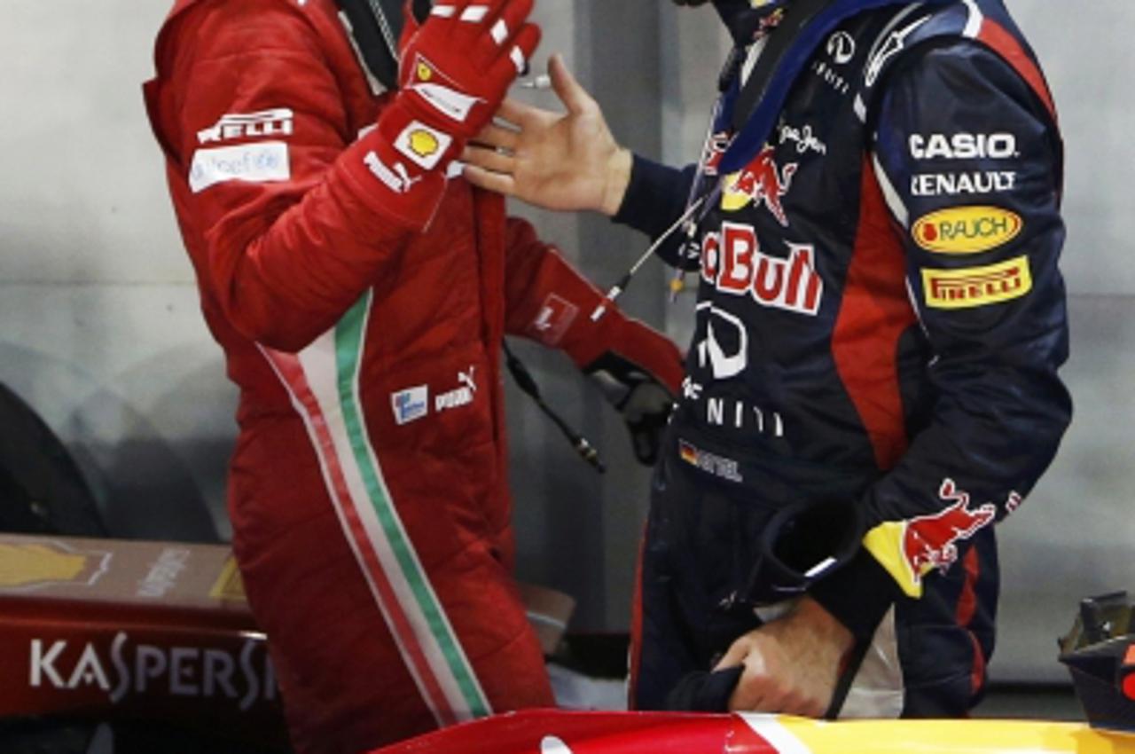 'Ferrari Formula One driver Fernando Alonso of Spain (L) congratulates Red Bull Formula One driver Sebastian Vettel of Germany after Vettel won the Singapore F1 Grand Prix at the Marina Bay street cir