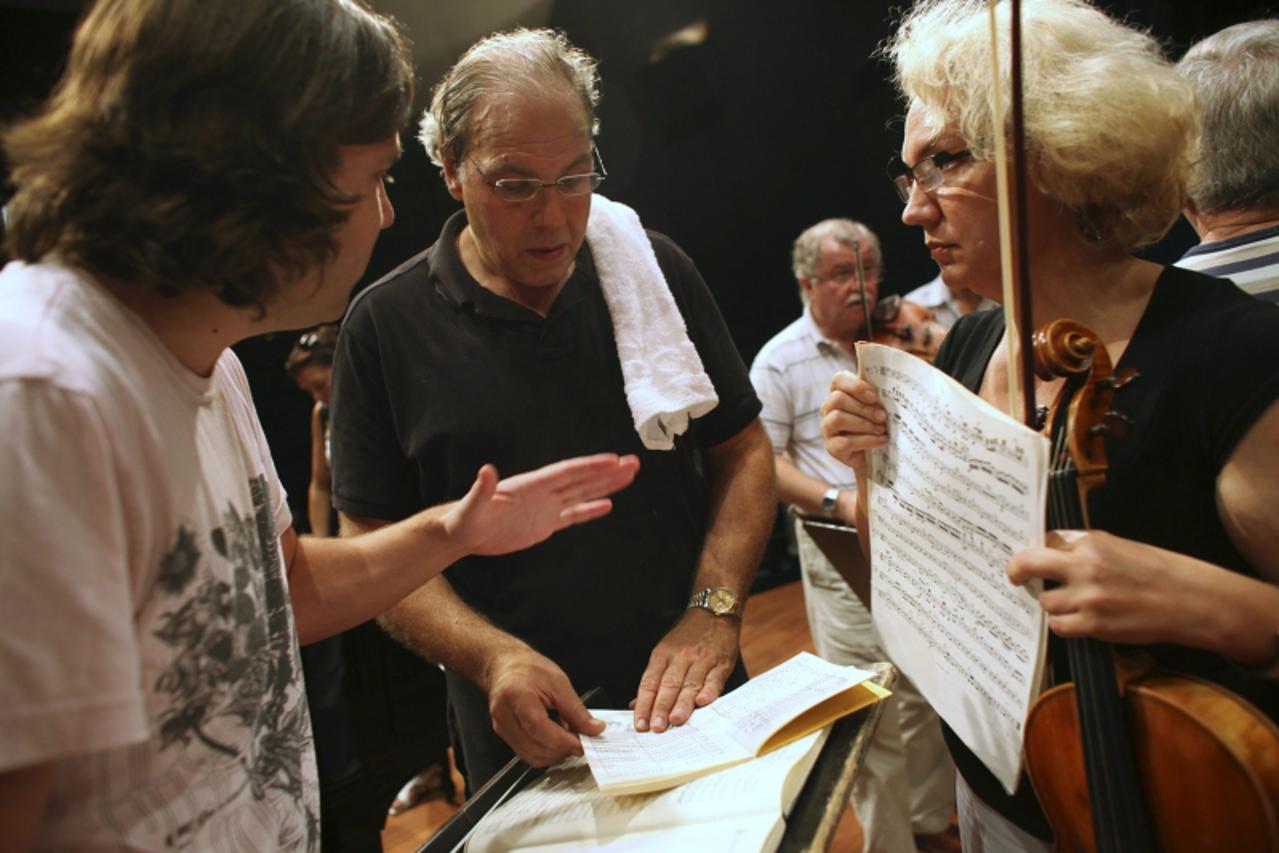 'Israel Chamber Orchestra\'s (ICO) conductor, Roberto Paternostro (C) stands with members from the orchestra during a rehearsal at the Tel Aviv Museum October 20, 2010. The ICO will strike an emotiona