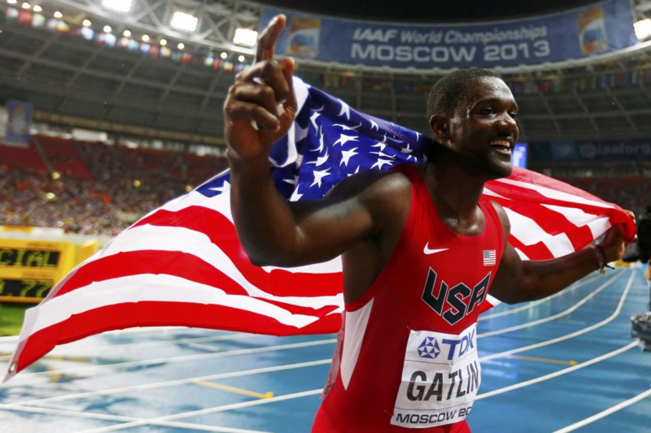 'Justin Gatlin of the U.S. holds his national flag as he celebrates finishing in second place in the men's 100 meters final during the IAAF World Athletics Championships at the Luzhniki stadium in Mo