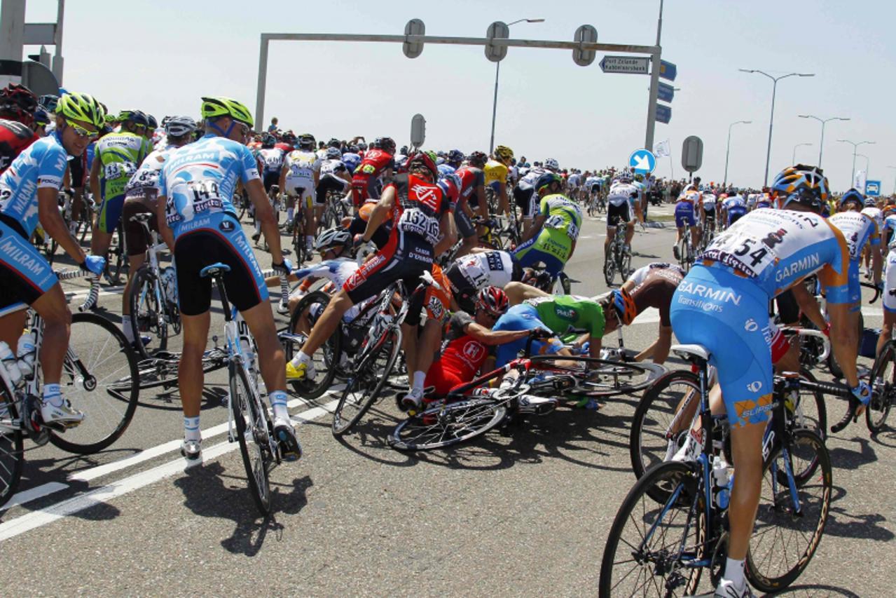 'Riders fall during the first stage of the Tour de France cycling race from Rotterdam to Brussels, July 4, 2010.  REUTERS/Bogdan Cristel (BELGIUM - Tags: SPORT CYCLING)'