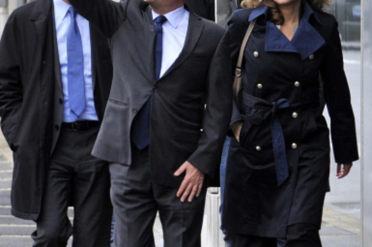 'France\'s opposition Socialist Party (PS) candidate Francois Hollande (C) flanked by his companion Valerie Trierweiler waves after voting during the first round of the 2012 French Presidential electi