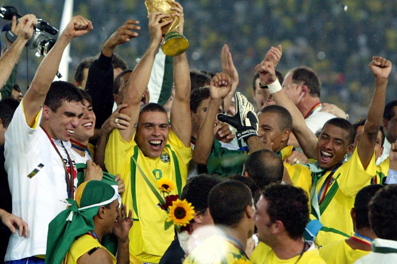 \'Brazil\'s Ronaldo holds up the trophy while celebrating with teammates after beating Germany in the World Cup final in Yokohama, in this June 30, 2002 file photo. Ronaldo announced his retirement on