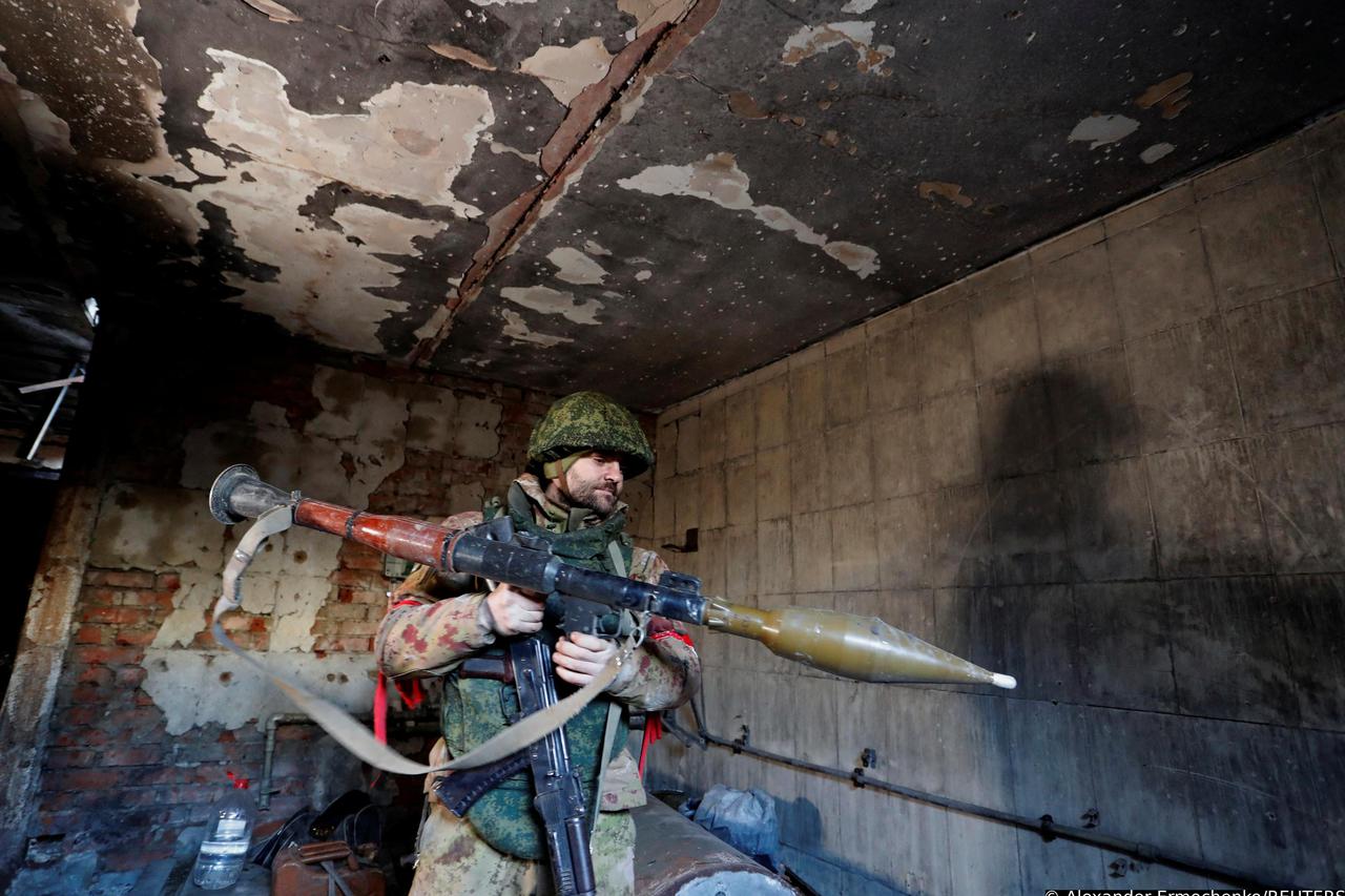 A service member of pro-Russian troops checks weapons inside a building, which according to the military, was previously a fighting position of Ukrainian armed forces, in Marinka