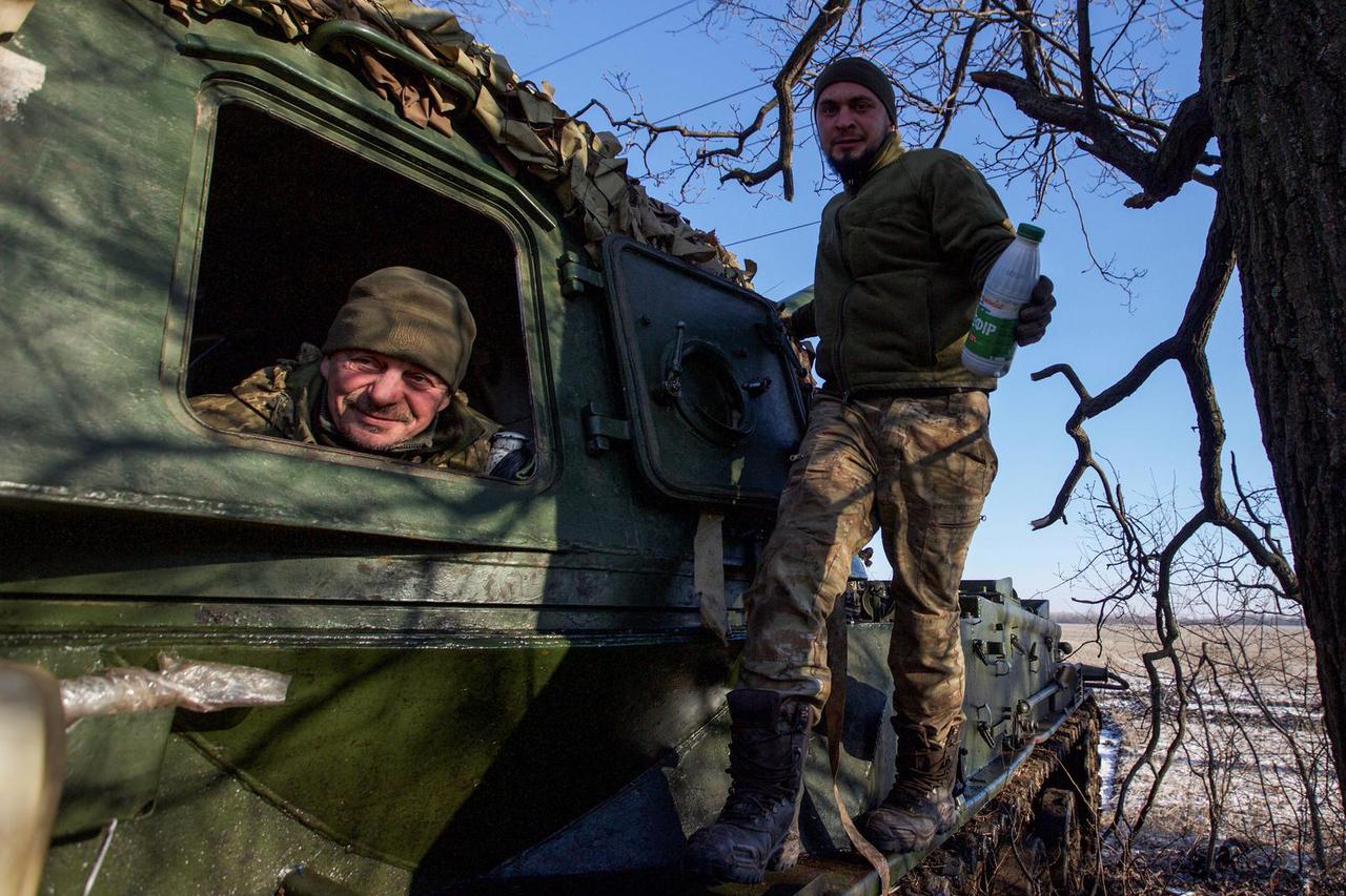 Ukrainian servicemen look on from 2S3 Akatsiya self-propelled howitzer at their position in a frontline in Donetsk region