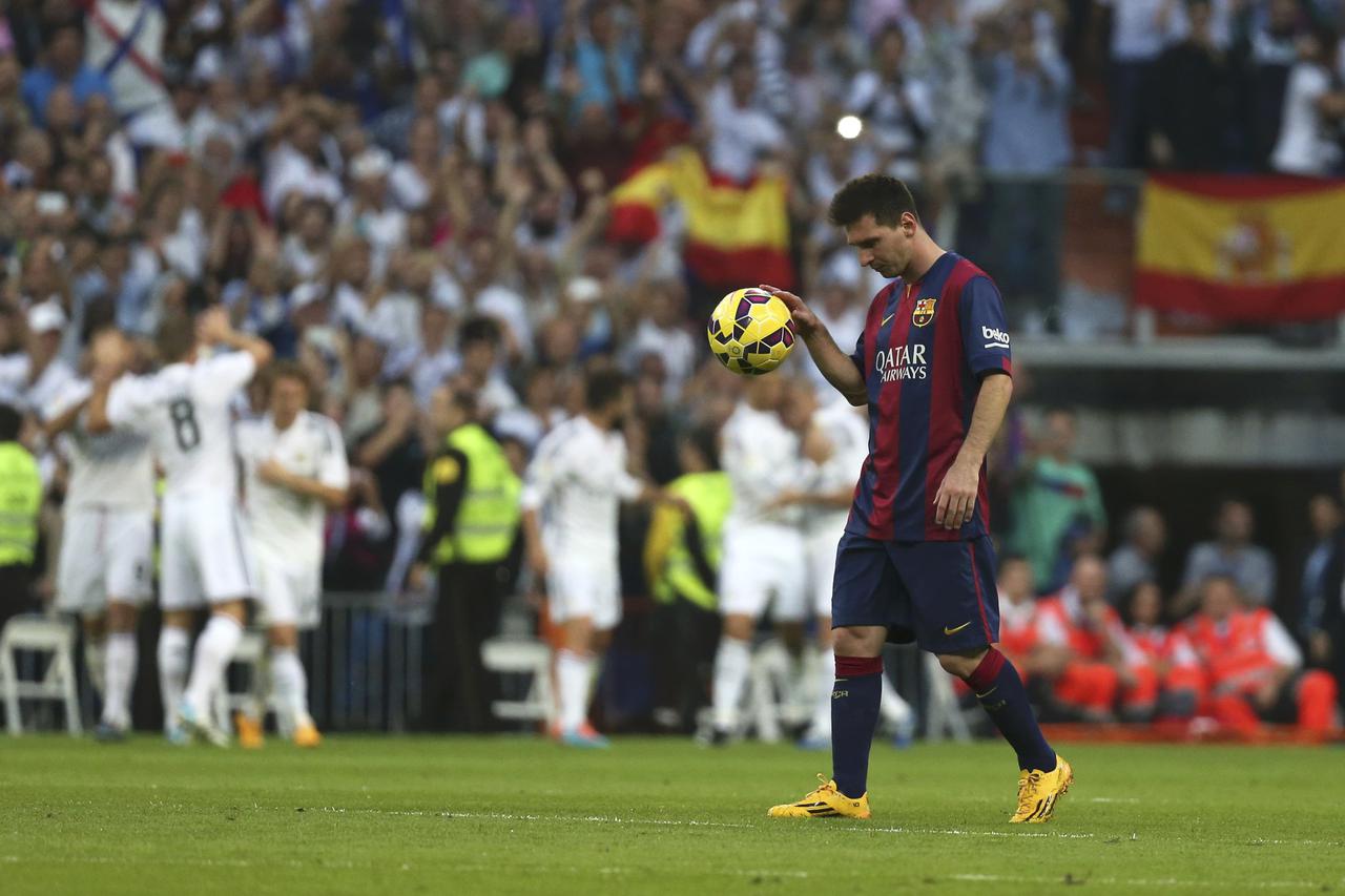 Barcelona's Lionel Messi bounces the ball after Real Madrid scored a third goal during their Spanish first division 