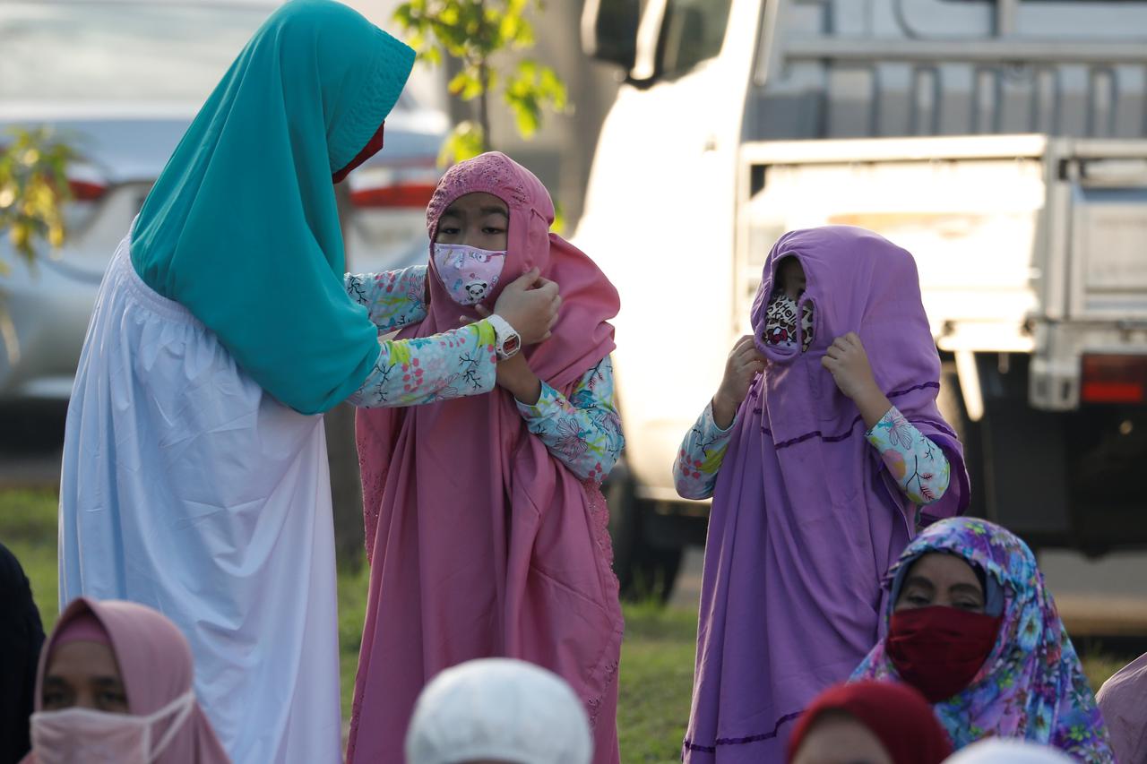 Indonesian Muslims wearing protective masks pray while celebrating Eid al-Fitr, the Muslim festival marking the end the holy fasting month of Ramadan