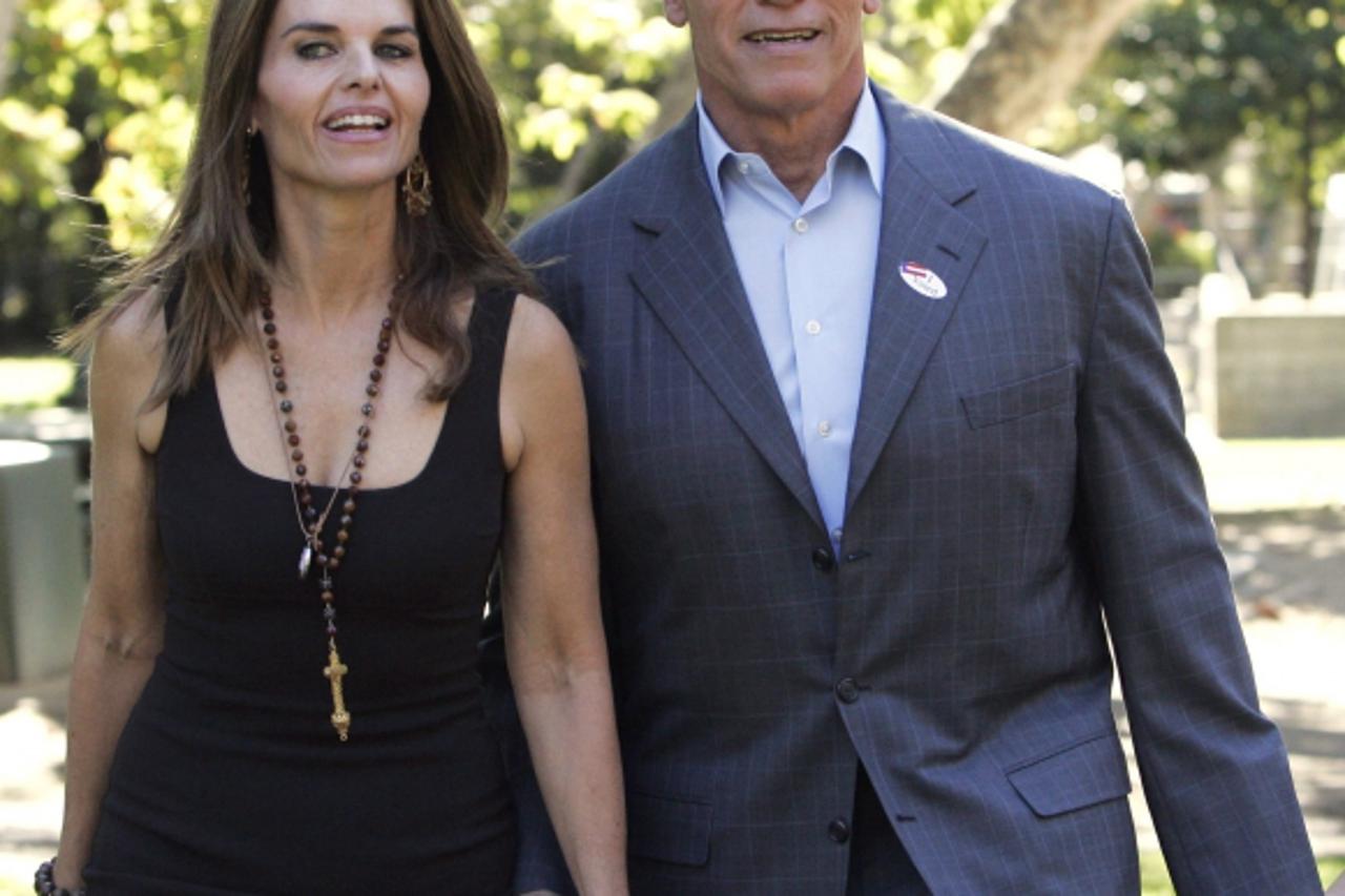 'California Governor Arnold Schwarzenegger holds hands with his wife Maria Shriver (L) as he walks to address the media after voting in the midterm elections at the Crestwood Hills Recreation Center i