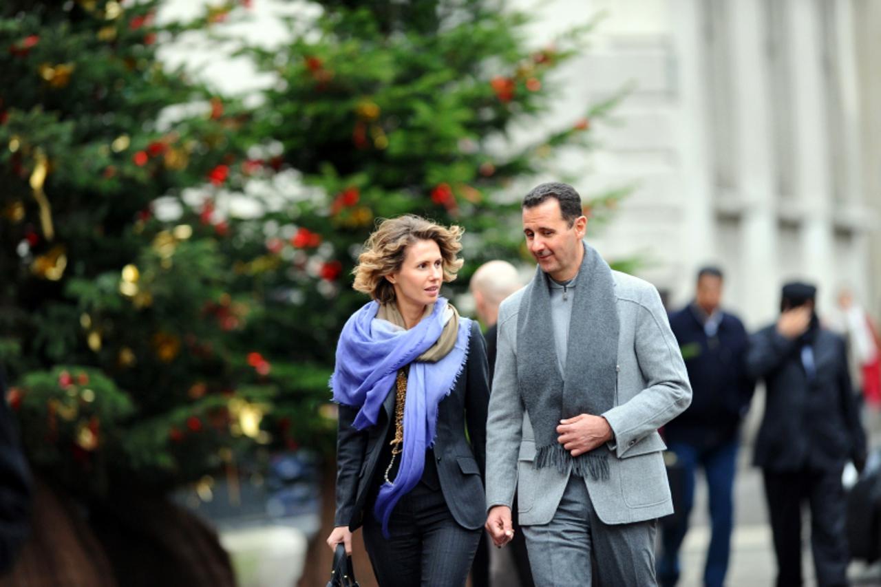 'Syrian president Bashar al-Assad and his wife Asma walk in a street of Paris on December 10, 2010. Al-Assad is on a two-days official visit to France.  AFP PHOTO MIGUEL MEDINA'