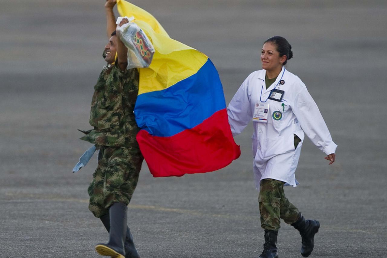 'A former FARC hostage (L) fluitters a Colombian national flag as he arrives in Villavicencio, Colombia on April 2, 2012, after being liberated. Colombia\'s leftist Revolutionary Armed Forces of Colom