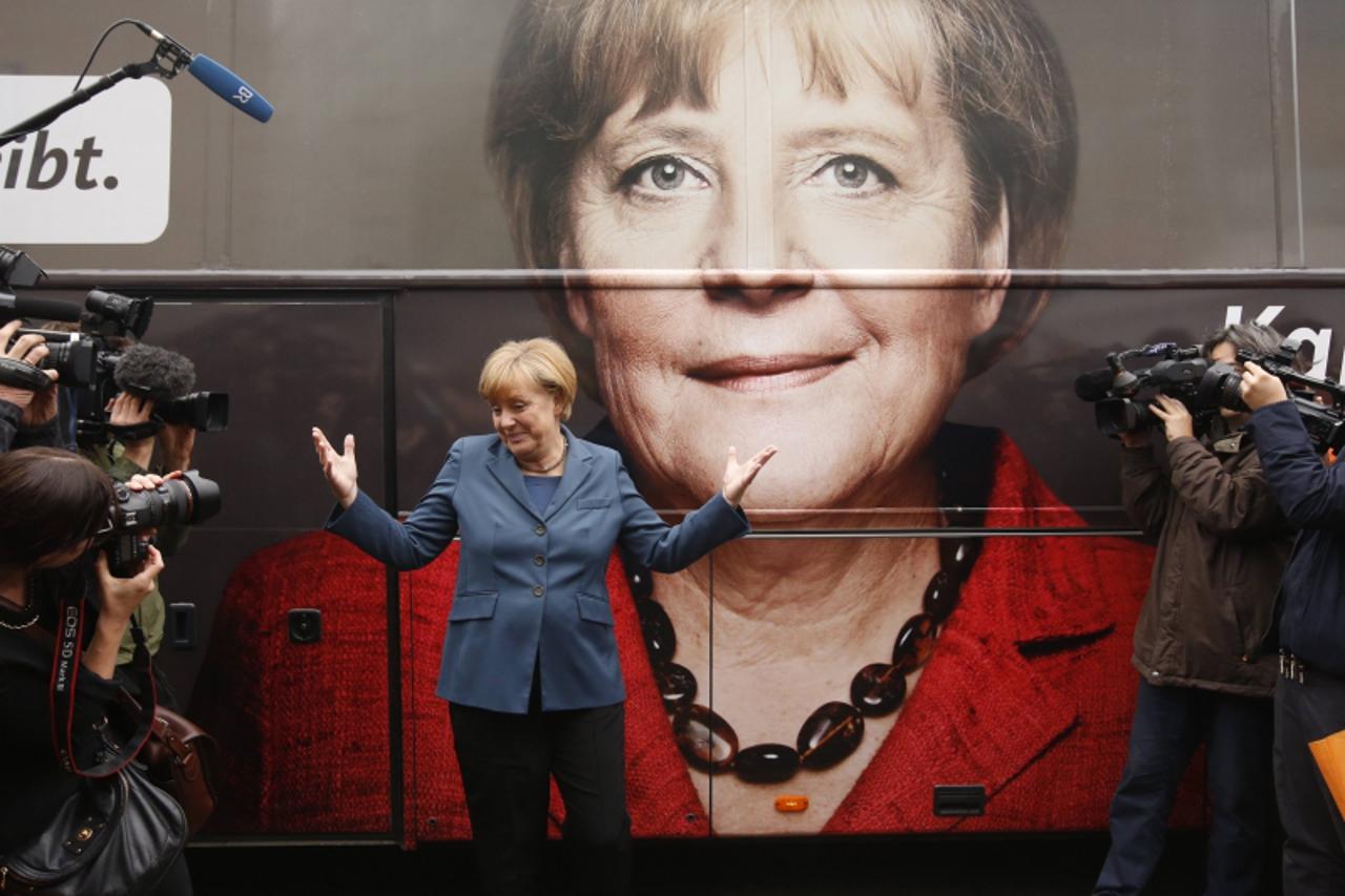 'German Chancellor Angela Merkel and leader of the Christian Democratic Union party CDU stands in front of her election campaign tour bus before a CDU board meeting in Berlin September 16, 2013. Merke