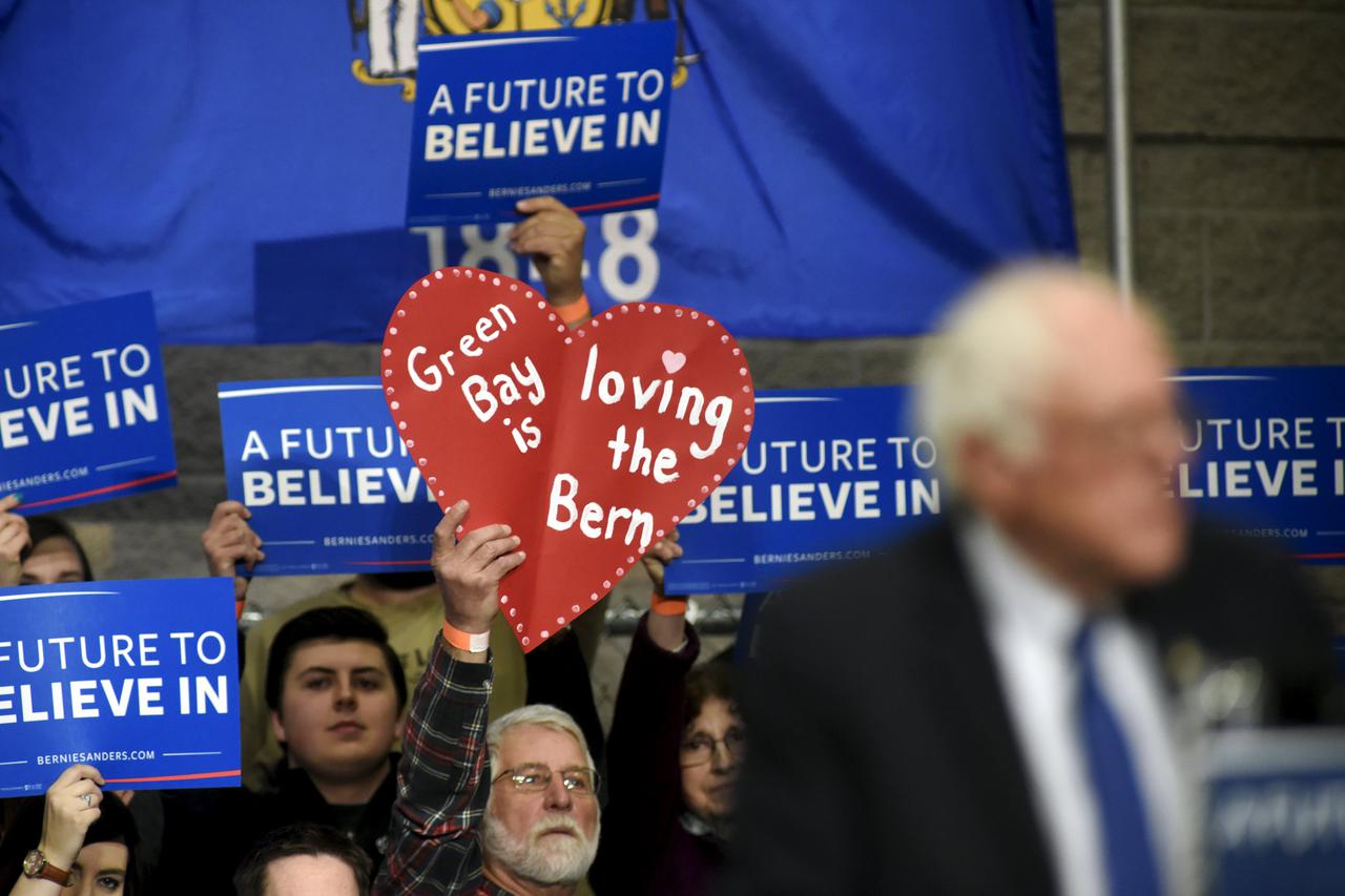 Supporters hold up signs as Democratic U.S. presidential candidate Bernie Sanders speaks at a campaign rally in Green Bay, Wisconsin April 4, 2016. REUTERS/Mark Kauzlarich