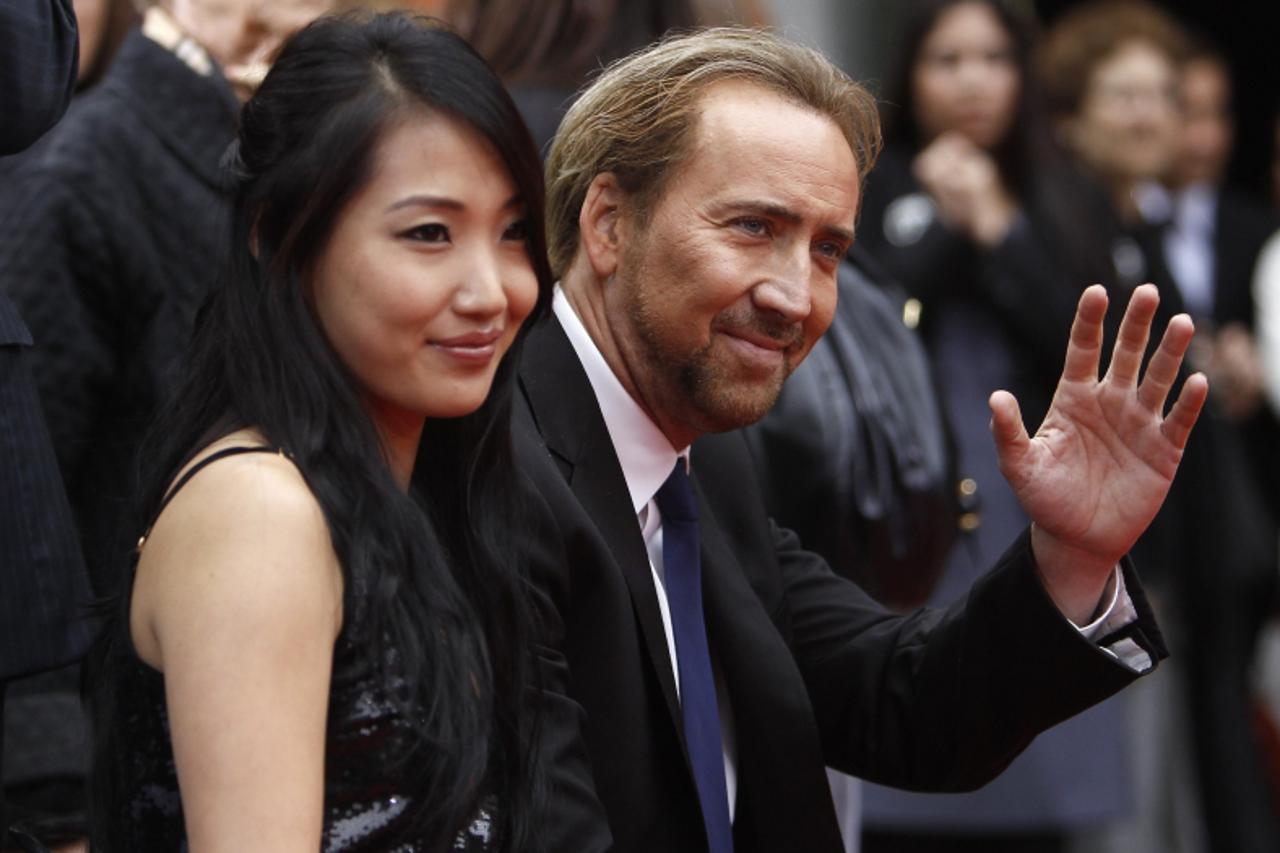 'Actor Nicolas Cage and his wife Alice Kim attend the hand and footprints ceremony for producer Jerry Bruckheimer at the Grauman\'s Chinese theatre in Hollywood, California in this May 17, 2010 file p