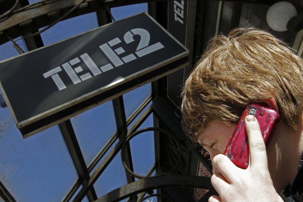 'A man talks on a telephone outside a branch of Nordic telecoms group Tele2 in St. Petersburg, March 28, 2013. Russian billionaire Mikhail Fridman is ready to trump state bank VTB's deal to buy Tele2